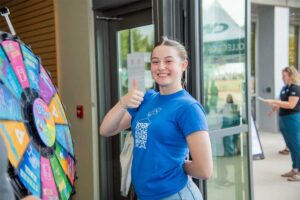student gives thumbs up after spinning a Wheel of Fortune Prize Wheel